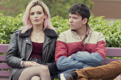 Maeve and Otis from Sex Education sitting on a bench