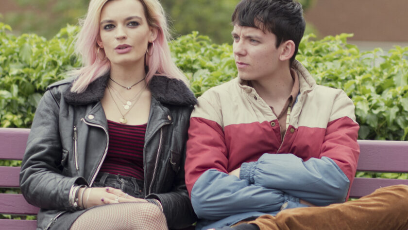 Maeve and Otis from Sex Education sitting on a bench